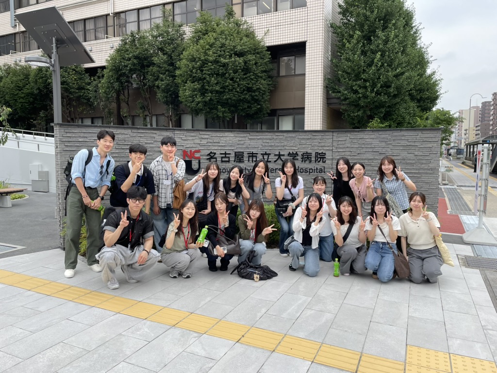 나고야시립대학 정문 앞에 한림대학교 간호대학 학생과 나고야시립대학 간호대학 학생이 단체 사진을 찍고 있다.