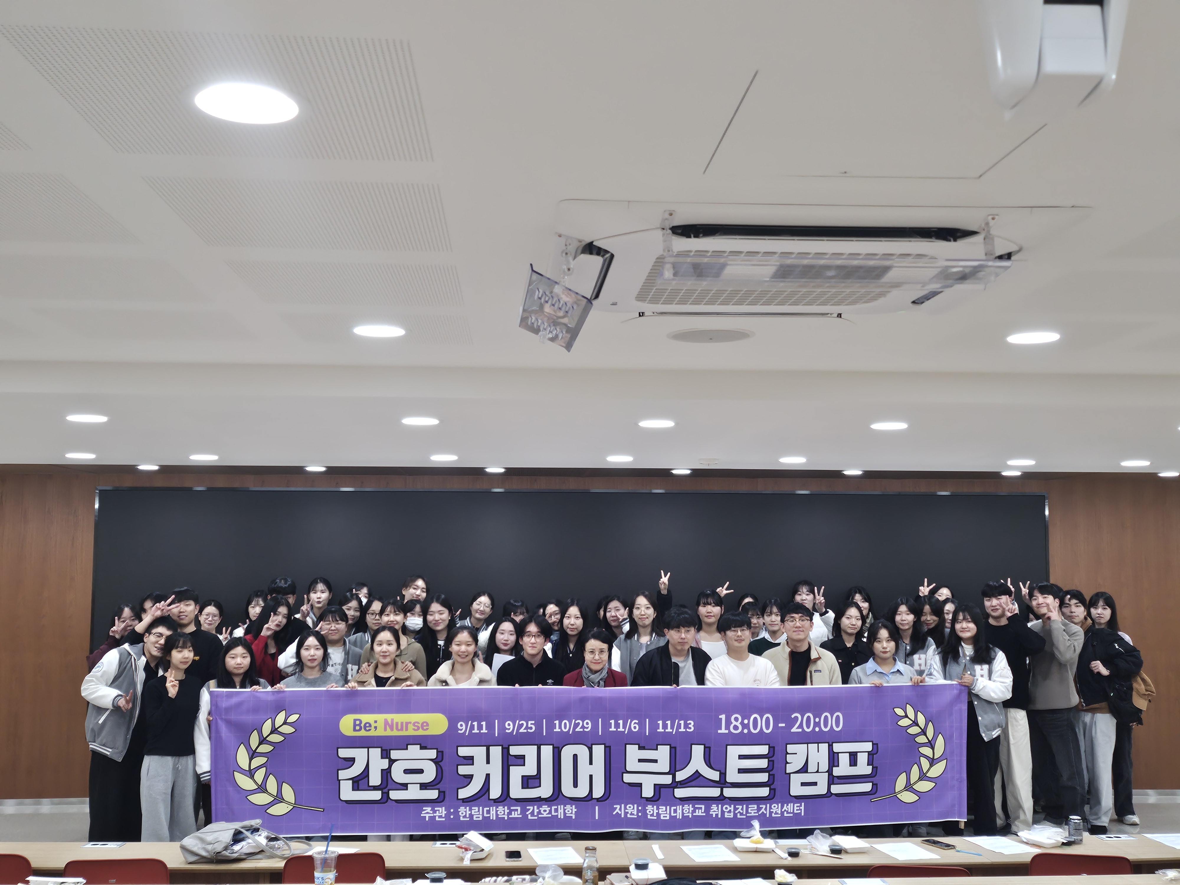 간호대학 재학생들이 간호 커리어 부스트 캠프 현수막을 들고 단체사진을 찍고 있다.