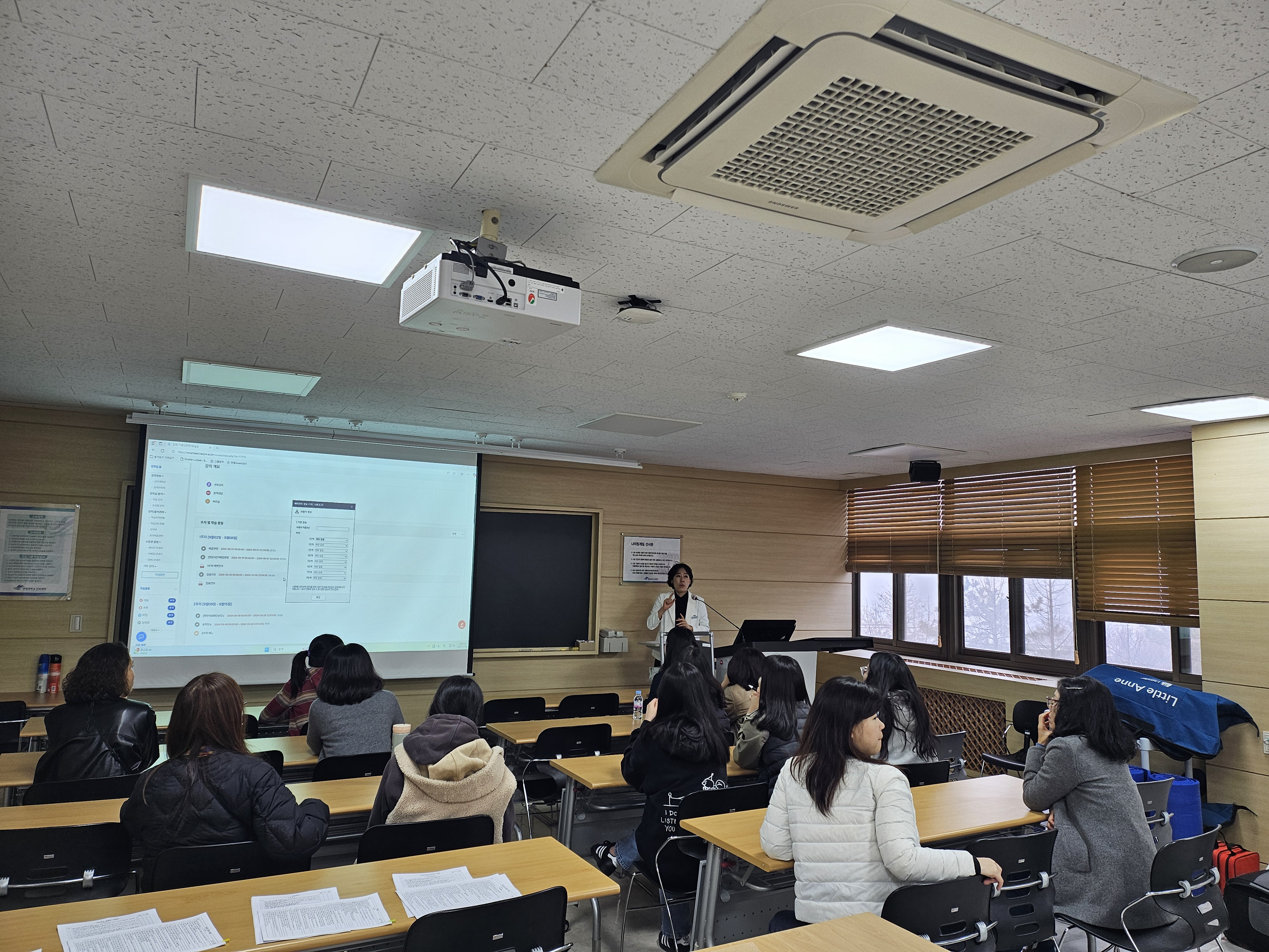 간호대학 교수님이 강의실에서 보건교사를 대상으로 교육연수 교육을 진행하고 있다.