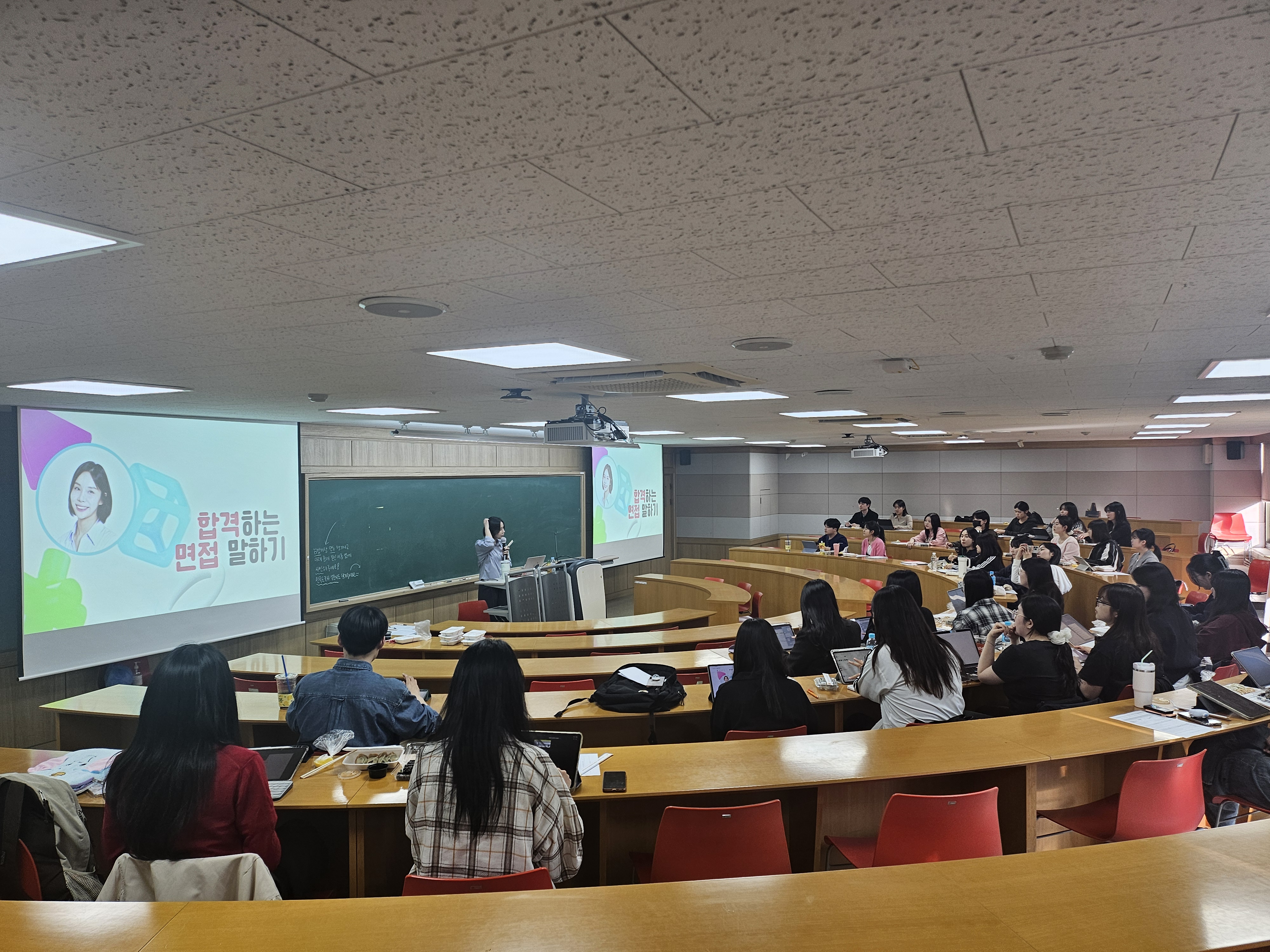 한림대학교 계단식 강의실에서 간호대학 재학생들이 취업특강을 듣고 있다. 강의실 스크린에는 합격하는 면접 말하기라고 적혀있다.